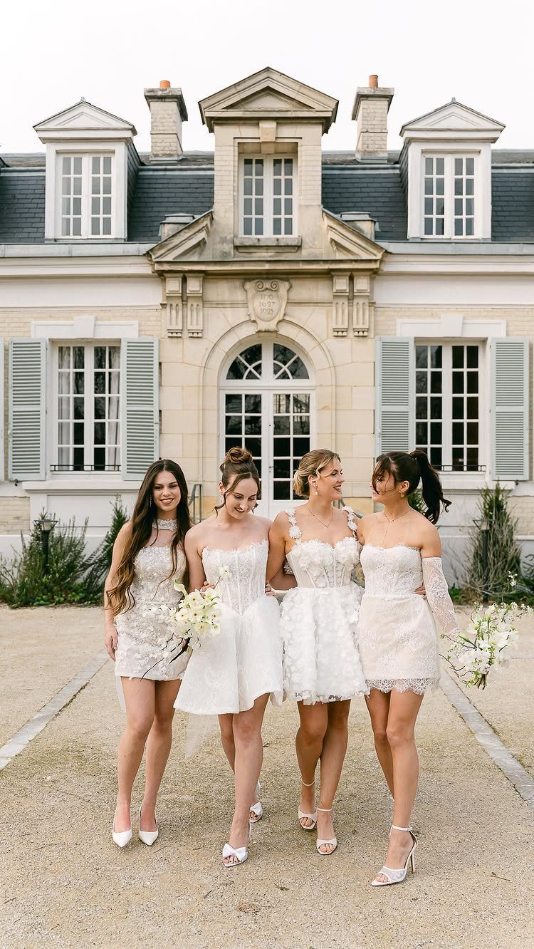 8 Civil Wedding Outfit Ideas for Brides Who Want Something Different 3 Four women posing in various white short lace dresses in front of a large mansion.