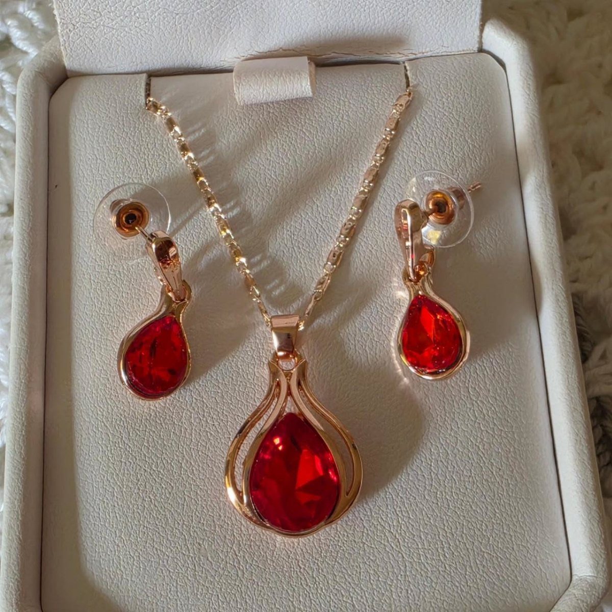 Crystal Jewelry Sets for 6 Style Moods 3 Rose gold necklace and earrings set with large teardrop-shaped red crystals in a white box.