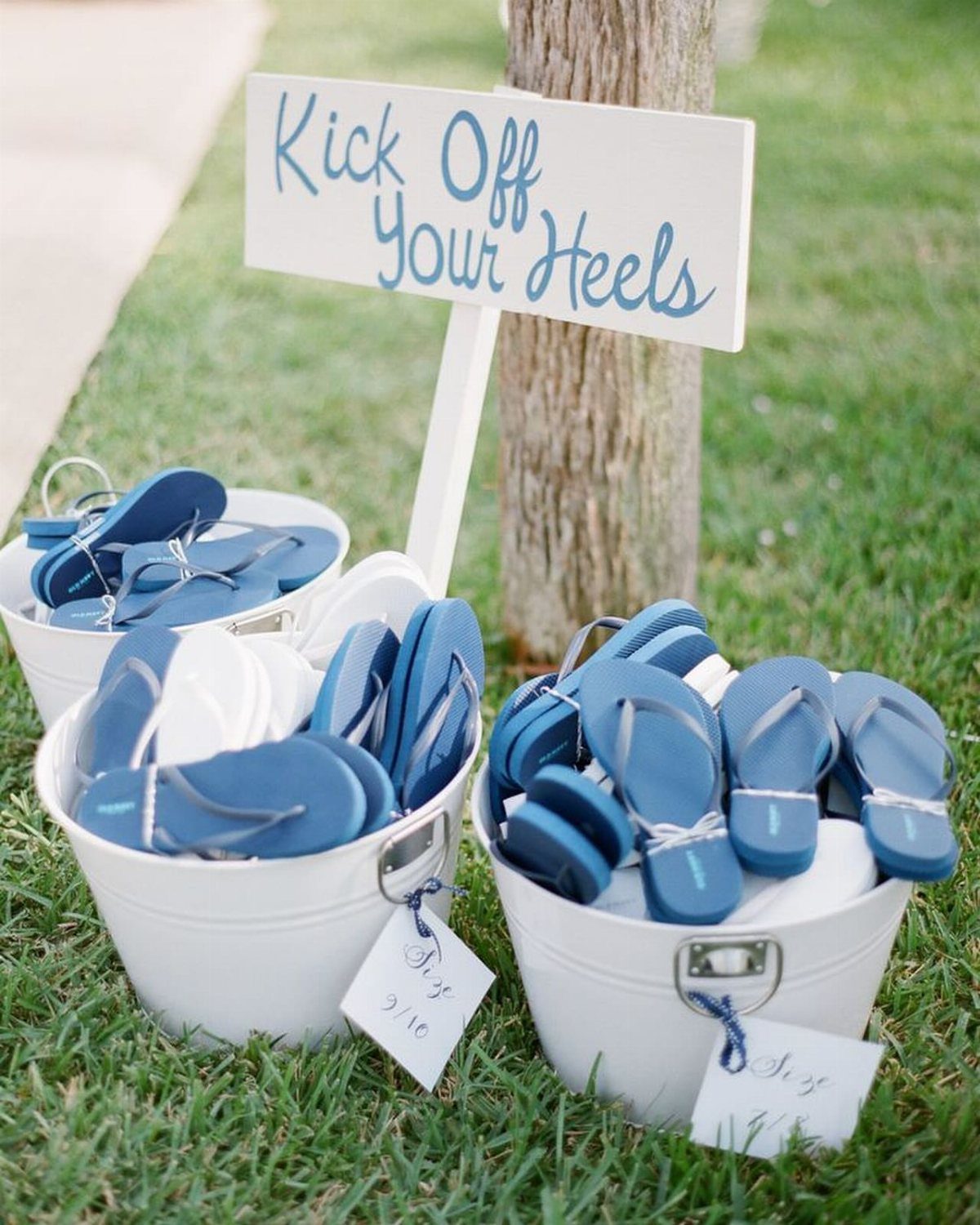 7 Cute Wedding Ideas for Guests, Photos and Reception Fun 3 Three white buckets filled with blue and white flip flops on a green lawn.