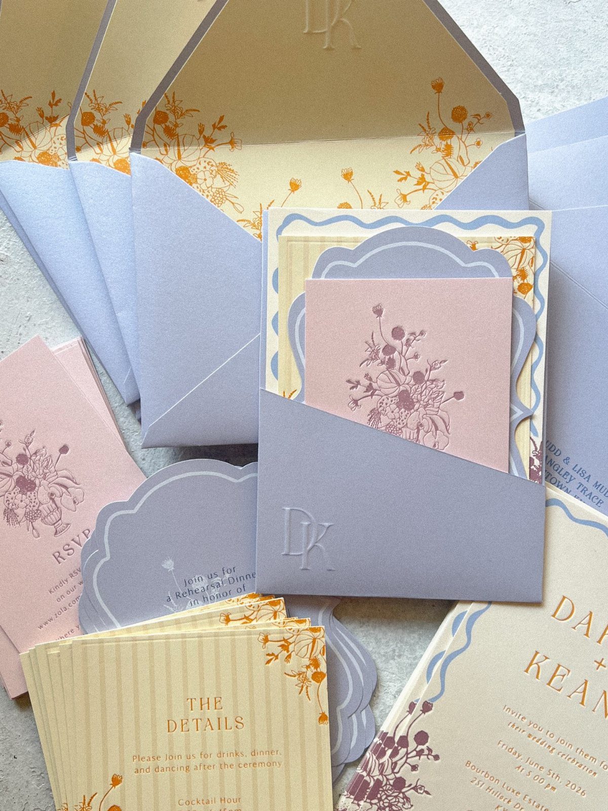 Wedding stationery set featuring floral patterned envelopes and botanical illustrated pink and cream cards.