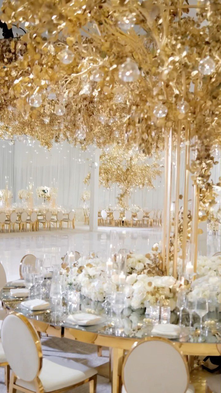 Gold and Champagne Wedding: 7 Ideas for a Warm, Metallic Celebration 6 Gold wedding reception tables with white flowers and a massive hanging gold floral installation.