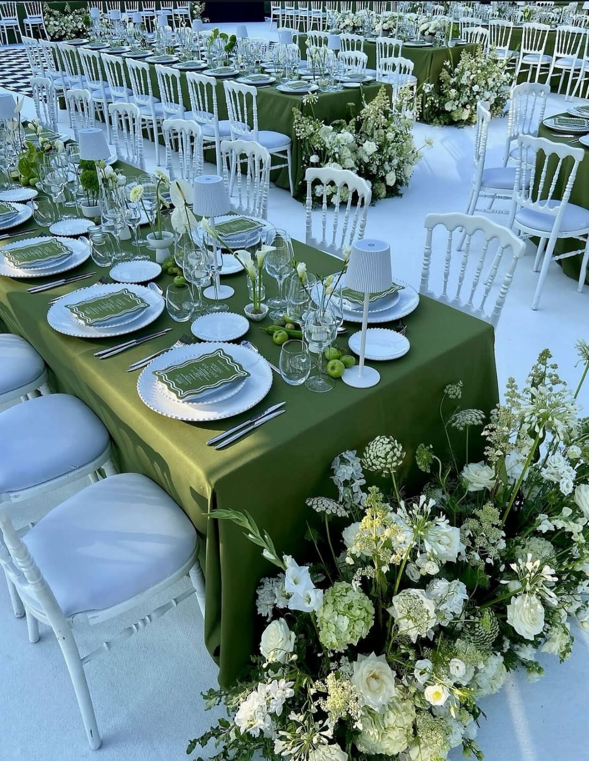 Green Wedding Colors: 8 Palettes From Olive to Emerald 1 Long banquet tables with olive green linens, white plates, and lush white floral arrangements.