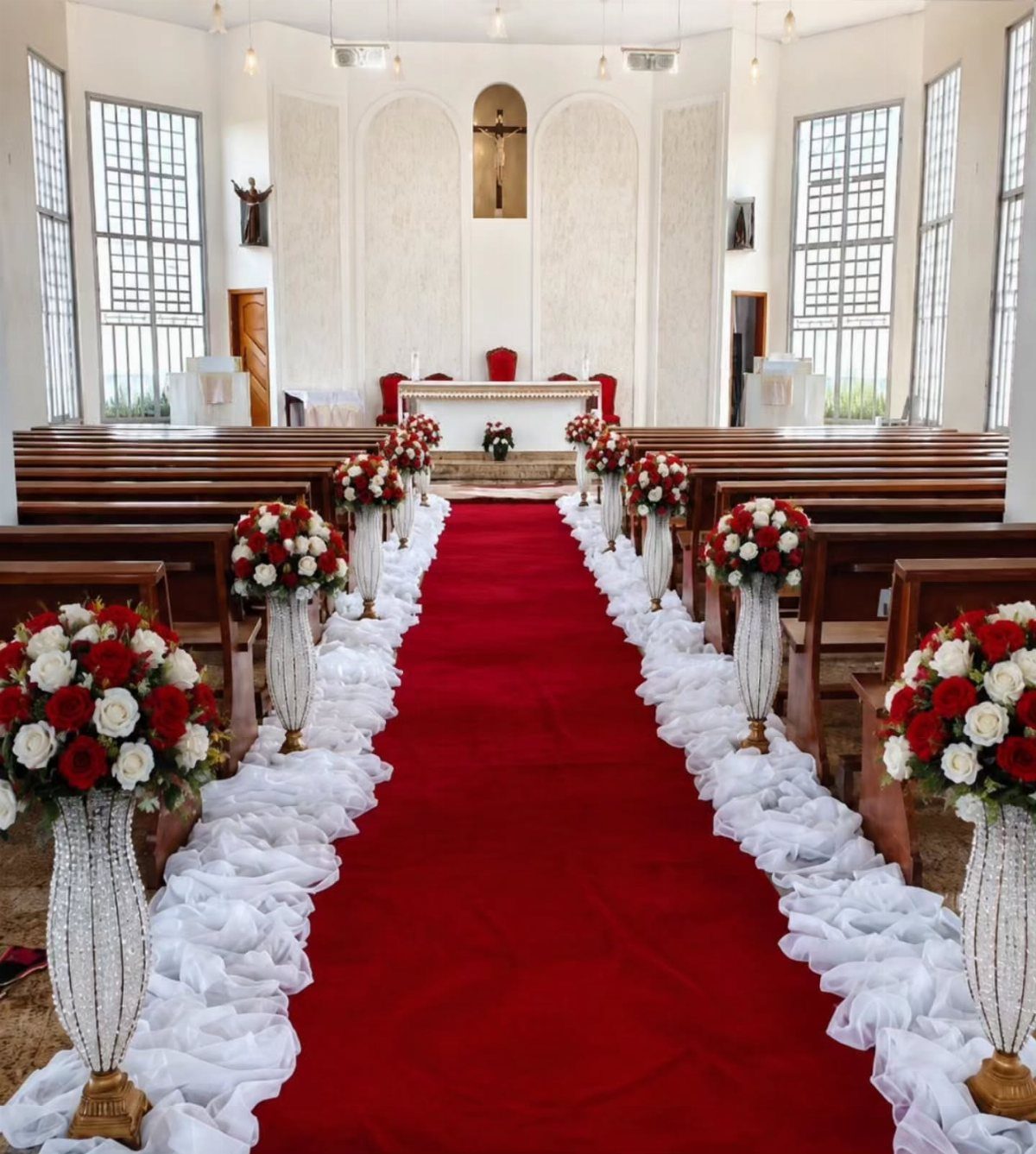 12 Ideas for a Red and White Wedding Theme 4 Red carpet aisle lined with white ruffles and red and white rose bouquets in a church.