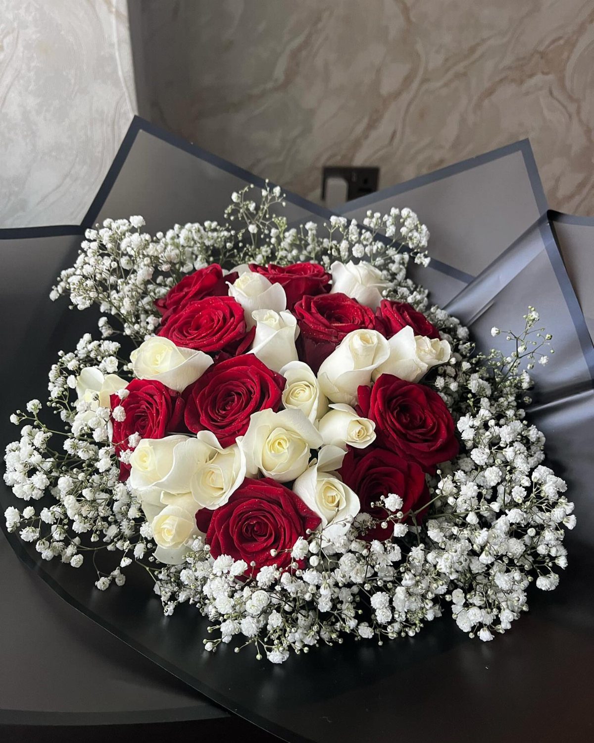 12 Ideas for a Red and White Wedding Theme 1 Red and white roses surrounded by delicate white baby's breath in a dark wrap.