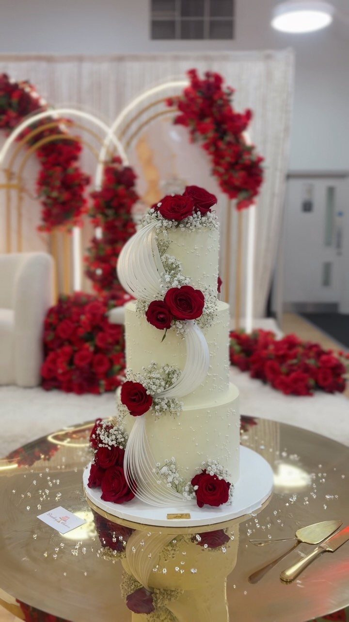 12 Ideas for a Red and White Wedding Theme 3 A three-tiered white wedding cake decorated with red roses and delicate white flowers.