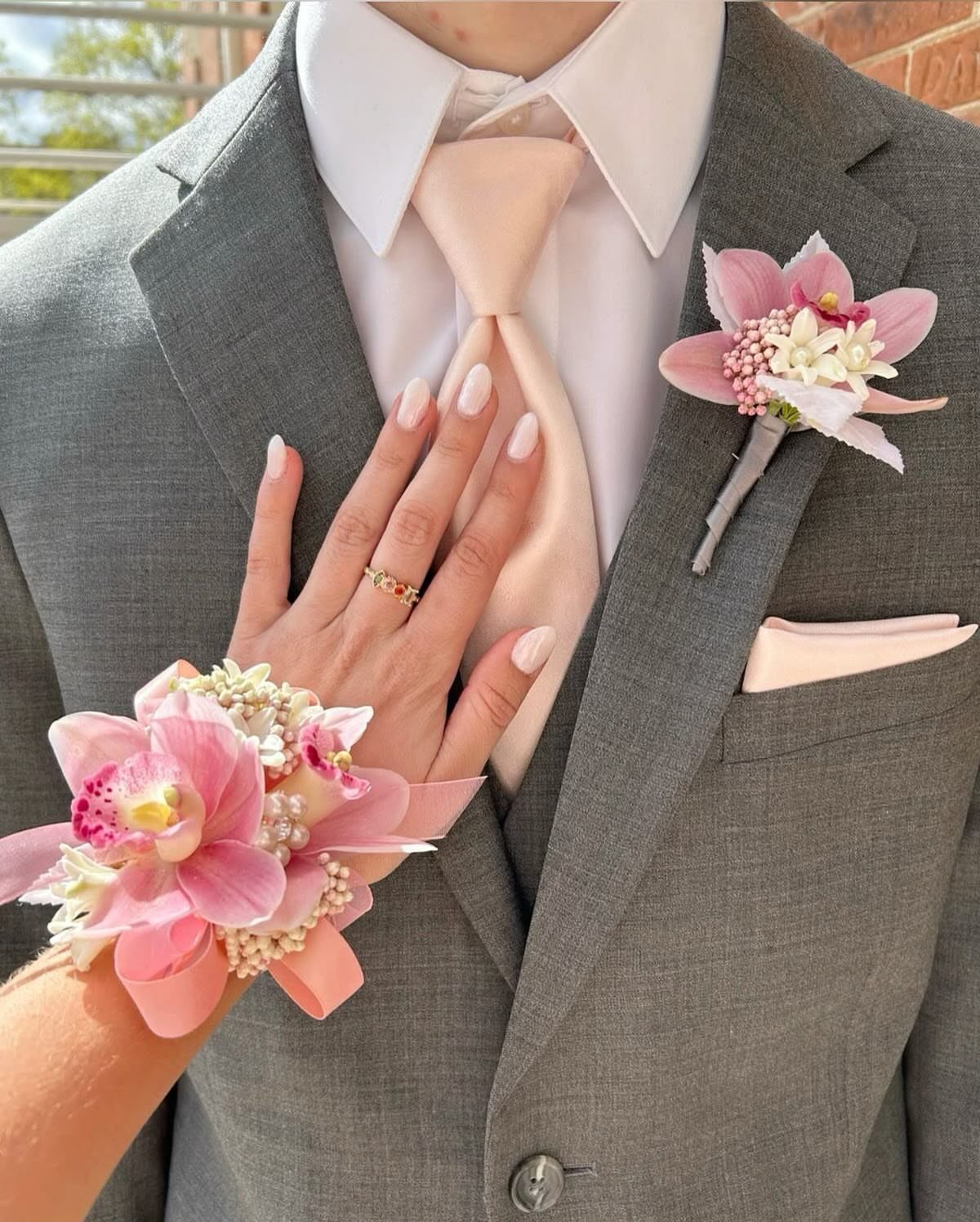 Wedding Decorations and Flowers: 8 Ideas for Ceremony to Reception 1 Pink orchid floral corsage on a wrist and matching boutonniere on a grey suit lapel.