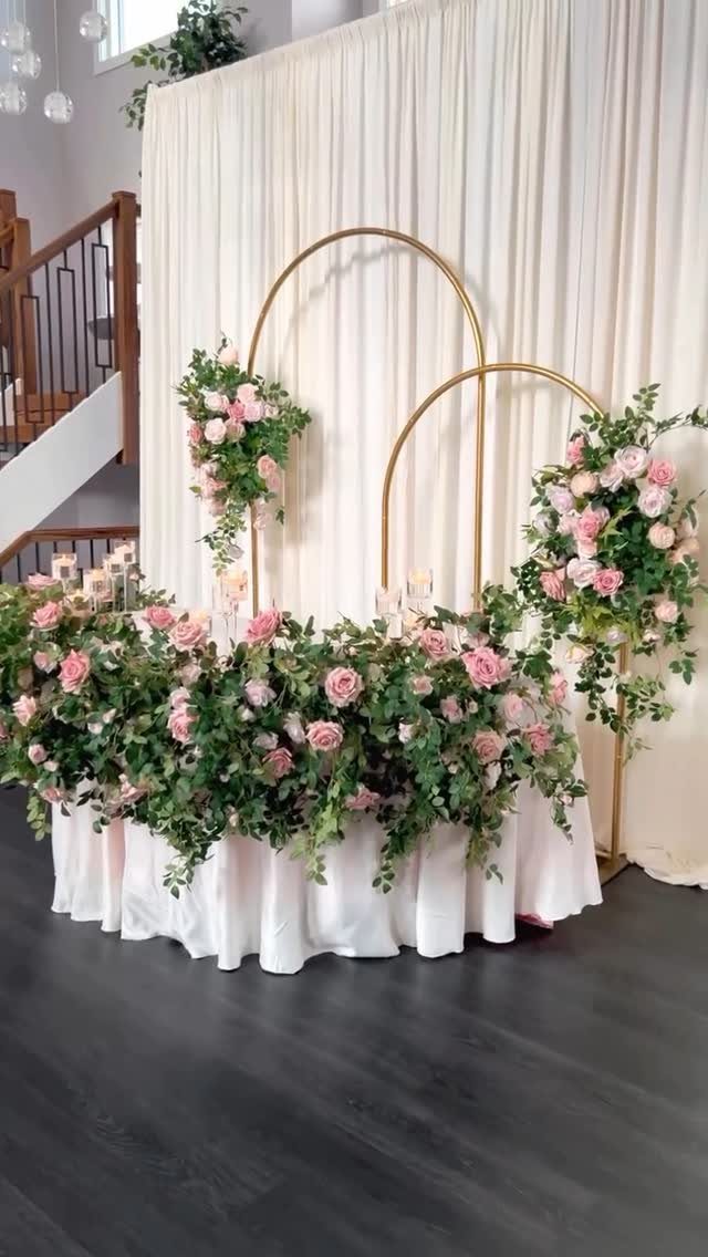 Wedding Decorations and Flowers: 8 Ideas for Ceremony to Reception 8 Pink roses and green foliage decorate a long table with gold circular arches in the background.