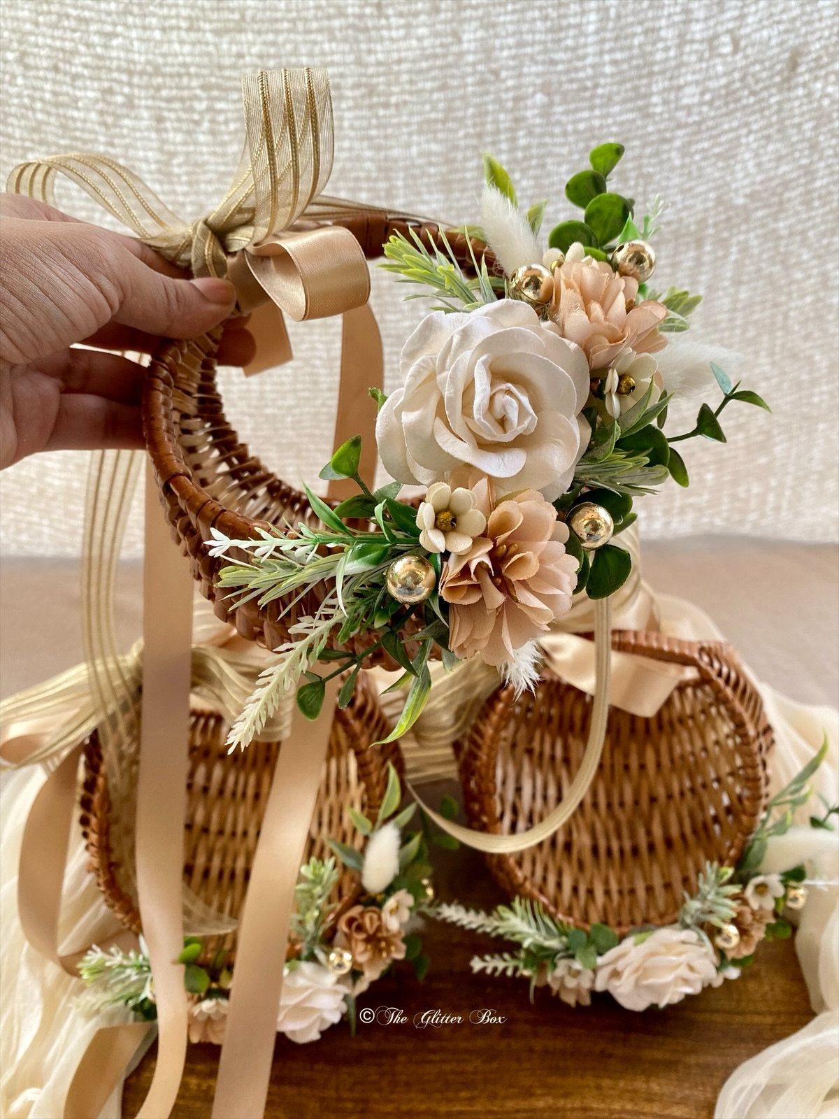Wedding Decorations and Flowers: 8 Ideas for Ceremony to Reception 7 A hand holds a small wicker basket adorned with cream fabric roses and greenery.