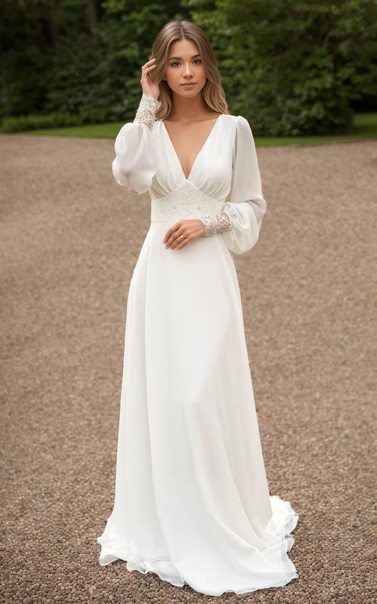 Wedding Dress Long Sleeve: 7 Styles From A-Line to Turtleneck 1 A woman in a white long-sleeve A-line wedding dress with lace details standing on gravel.