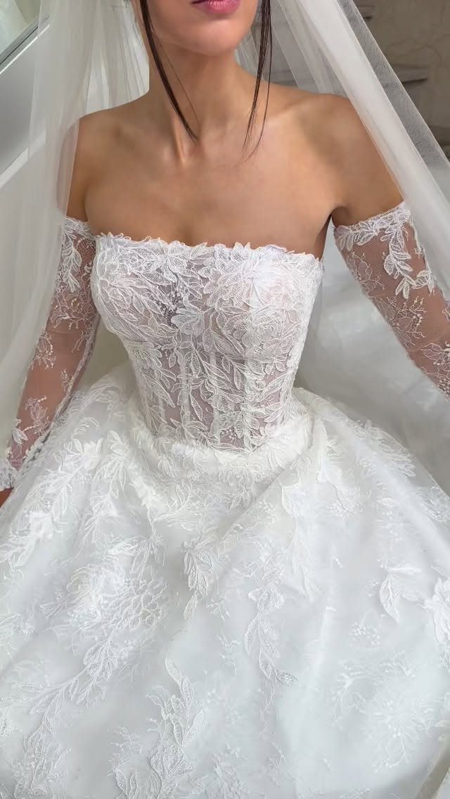 Wedding Dress Long Sleeve: 7 Styles From A-Line to Turtleneck 2 Woman wearing a white lace wedding gown with long lace sleeves and a corset bodice.